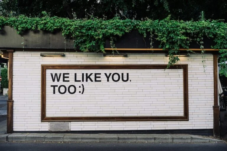 Wall sign reading We like you. Too