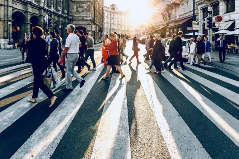 Crowd crossing a city street on a marked crosswalk
