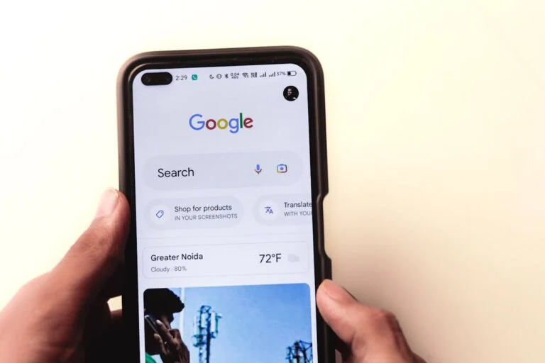 Hands holding a phone with the Google search app open