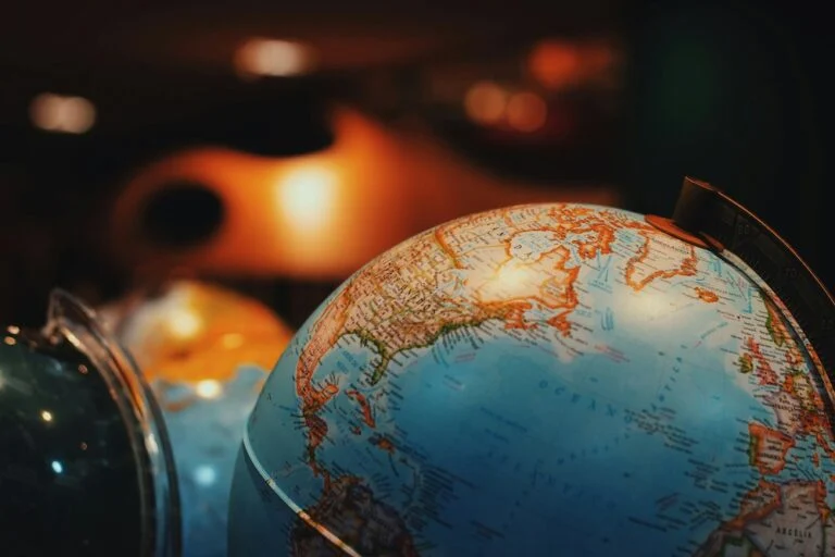 Antique globe lit in orange against a dark background
