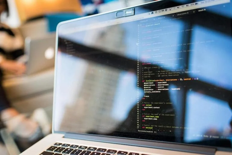 Laptop on a desk showing lines of code