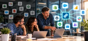 Three coworkers around two laptops, a scattered cluster of business app icons on one side and the same icons linked to a central gear hub on the other